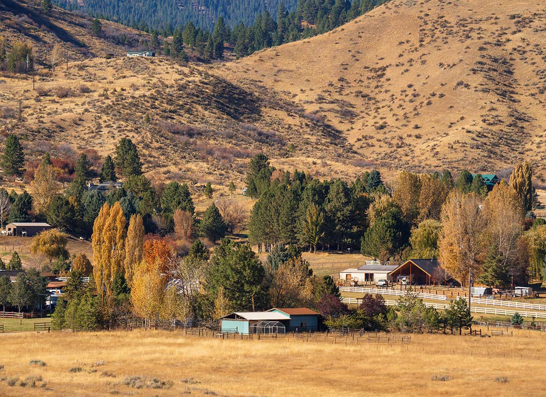 Kuna, ID - View of Homes Surrounded by Fall Colored Trees Next to the Mountains in a Rural Area in Kuna Idaho